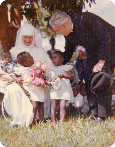 Archbishop Sheen with children and rosaries